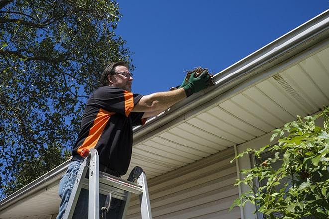 roofer fixing a sagging gutter on a building in Berkley